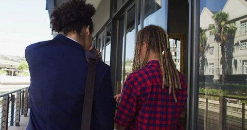 Two Men Walking Along Waterfront Promenade Wearing Blazer and Plaid Shirt Dreadlocks