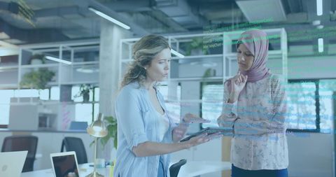 Diverse Businesswomen Collaborating on Financial Data in Modern Office