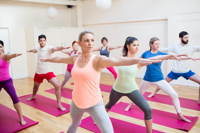 Group of people performing stretching exercise in the fitness studio