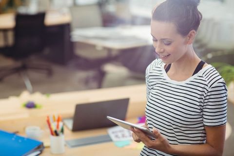 Woman Engaging with Tablet in Modern Office Workspace