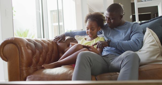 Father Reading Book with Daughter on Leather Couch in Bright Living Room - Download Free Stock Images Pikwizard.com