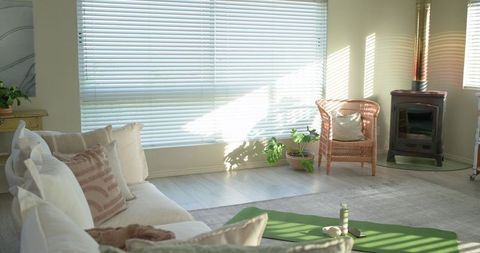 Sunlit Minimalist Living Room with Yoga Mat, Cozy Beige Sofa and Wicker Chair