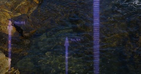 Digital Arrows Display Data Over Rocky Shoreline