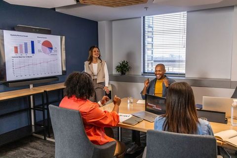 Multiracial team presenting growth charts and celebrating success in conference room
