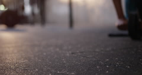 Hand Using Ab Wheel for Workout on Gym Floor with Focused Foreground