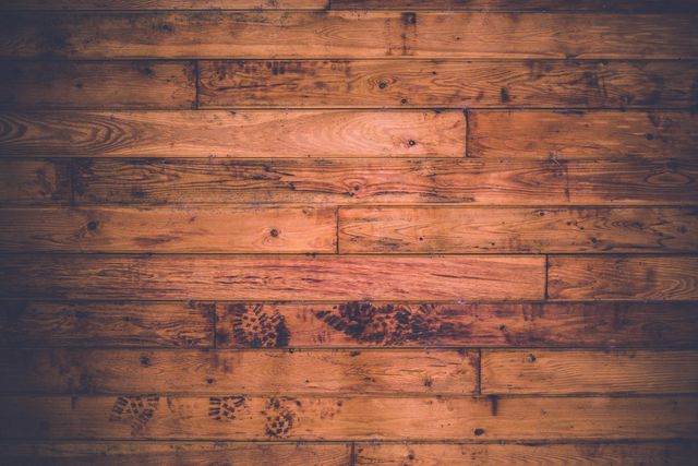 This rustic wooden floor with distressed planks and natural patterns captures the charm of aged hardwood. Warm tones and natural textures suggest a cozy, vintage atmosphere, making it ideal for use in interior design projects, advertisements for home improvement products, background for photography, or creating mood boards for rustic-themed decor. The visual appeal of the aged wood brings a touch of authenticity and timeless beauty to any visual content.