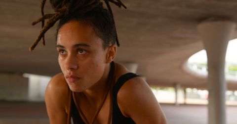 Female Athlete Resting Under Urban Bridge