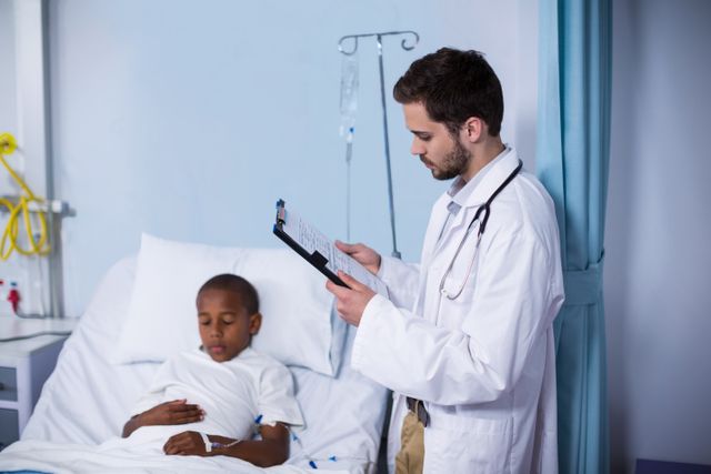 Doctor looking at report while patient sleeping on bed - Download Free Stock Photos Pikwizard.com