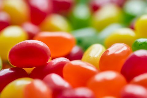 Macro close-up of colorful jelly beans with glossy shells forming vibrant candy mosaic