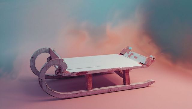 Vintage wooden sled with pastel gradient background
