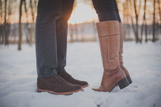 Couple Standing in Snow Wearing Winter Boots at Sunset - Download Free Stock Photos Pikwizard.com