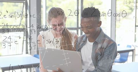 Students collaborating with laptop to solve math equations in classroom