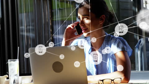 Businesswoman Networking Globally via Smartphone and Laptop