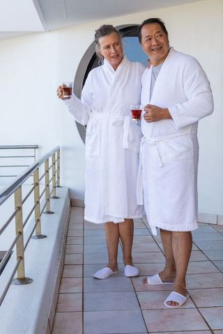 Senior Couple Relaxing on Cruise Ship Balcony in Luxury Robes