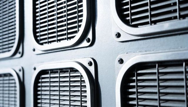 Close-up industrial vent grilles with metal louvers and symmetric equipment panel detail