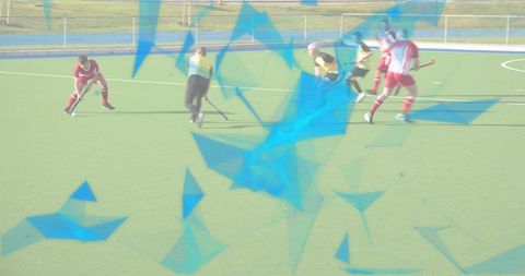 Field hockey players competing for ball on turf during intense outdoor team match action