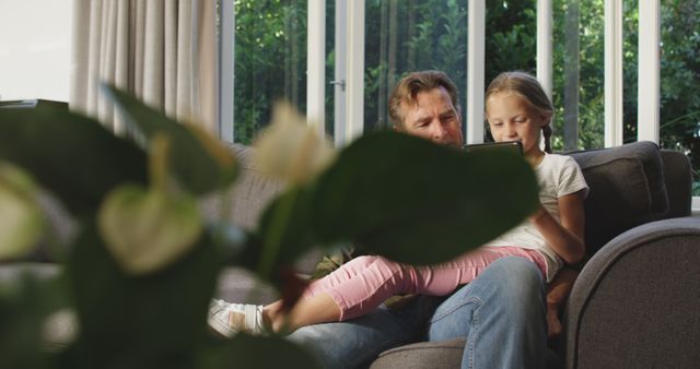 Father and Daughter Reading Digital Tablet on Sofa at Home - Download Free Stock Images Pikwizard.com