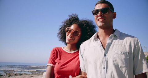 Smiling Couple Walking on Beach Promenade on Sunny Day