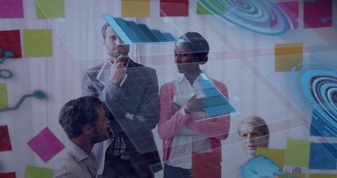 Team analyzing holographic blue charts on glass panel during collaborative brainstorming