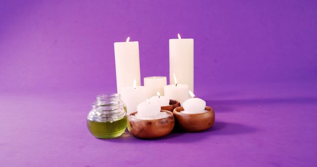 Lit White Candles with Wooden Bowls and Oil Jar on Purple Background - Download Free Stock Images Pikwizard.com