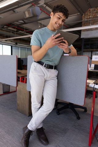 Young Professional Engaging with Tablet in Modern Office Space