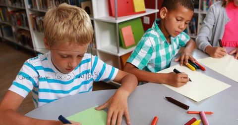 Elementary students collaborating on creative projects in library