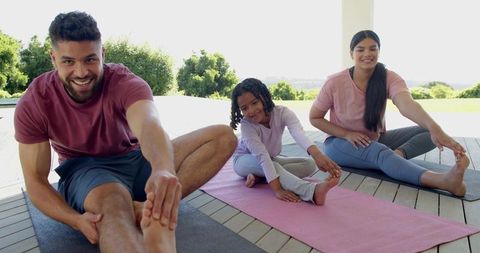 Family Practicing Yoga Together Outdoors on Sunny Patio