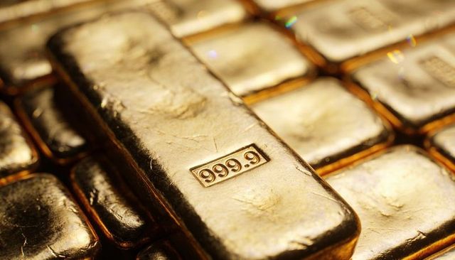 Stacked gold bullion bars showing 999.9 purity reflecting warm metallic luxury and wealth