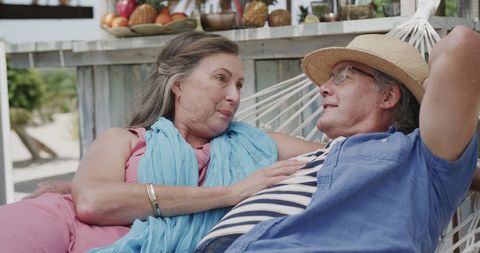 Happy Senior Couple Relaxing in Hammock on Beach Vacation