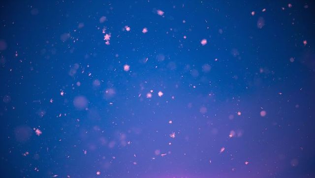 Floating Snowflakes Against Ethereal Violet Winter Sky