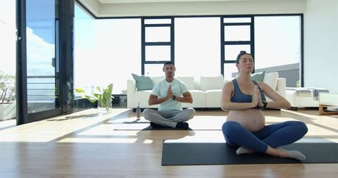 Pregnant Woman Practicing Yoga with Friend in Modern Living Room