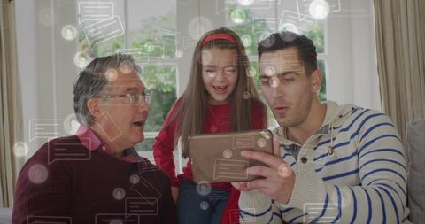 Multigenerational family sharing tablet, reacting with surprise on living room sofa
