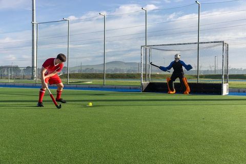 Intense Field Hockey Match on Sunny Day with Focused Players