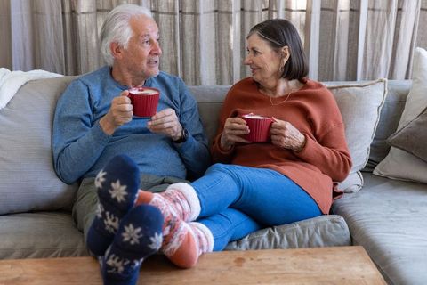 Senior Couple Enjoying Cozy Time with Coffee on Sofa
