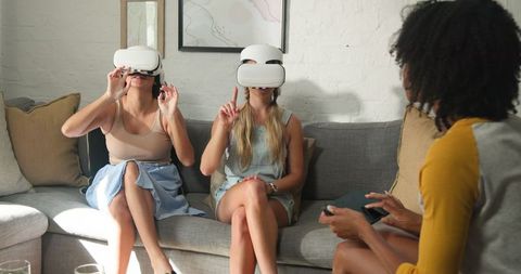Friends Exploring Virtual Reality Together on Cozy Sofa