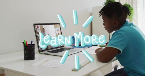 Student studying at laptop doing worksheets with learn more graphic, remote learning desk
