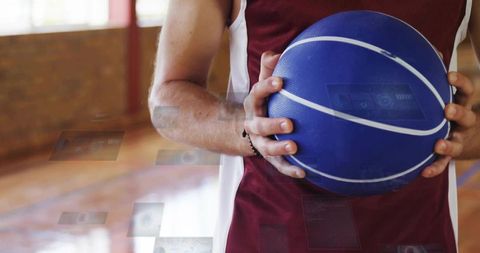 Athlete Holding Blue Basketball Preparing for Game on Indoor Court