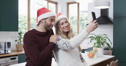 Happy Couple Taking Christmas Selfie in Festive Kitchen