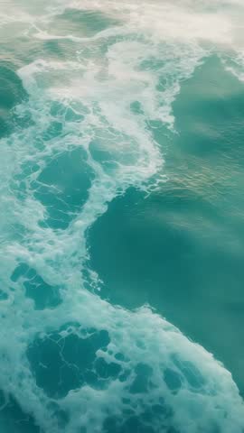 Vertical video: boat leaving churning wake in turquoise ocean with swirling foam patterns