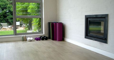 Featuring home yoga corner with rolled mats, dumbbells, towels and garden view