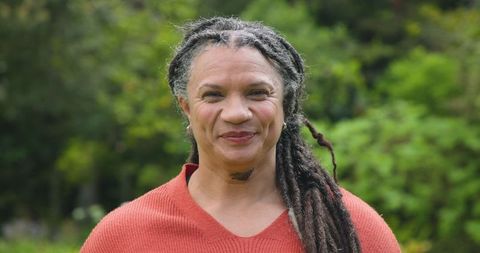 Senior Woman Smiling in Lush Garden Setting