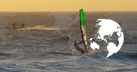Riding windsurfer at sunset with green sail and global dot map overlay
