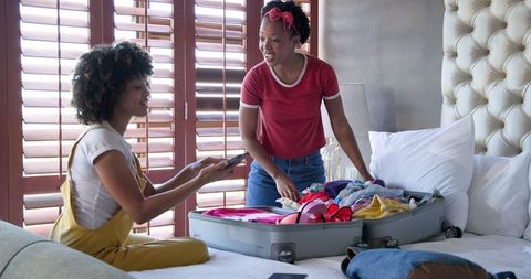 Diverse Female Couple Packing for Vacation at Home