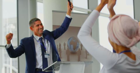Businessman Celebrating Success at Conference with Applauding Audience
