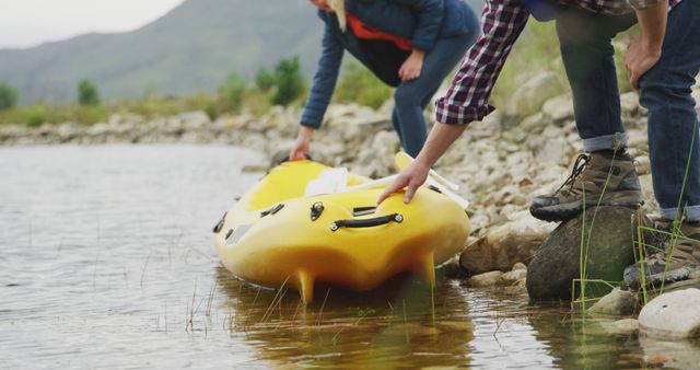 Caucasian couple getting into kayak in lake water with copy space. Nature, travel, tranquility, lifestyle concept, unaltered.