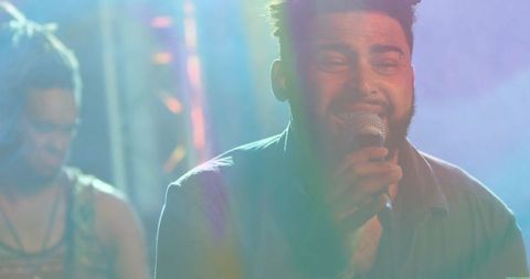 Vocalist performing live on stage with vibrant stage lights