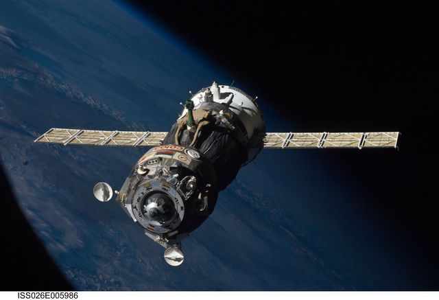 Soyuz TMA-19 spacecraft detaching from the International Space Station with Earth and the blackness of space contrasting in the background. Can be used for space exploration articles, educational materials about human spaceflight, technology displays, or historical documentation of space missions.