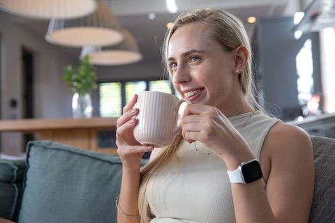 Woman Relaxing with Coffee in Modern Open-Plan Living Room