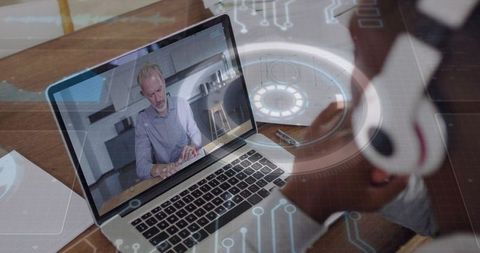 Watching remote video meeting with consultant on laptop and headset displaying digital interface