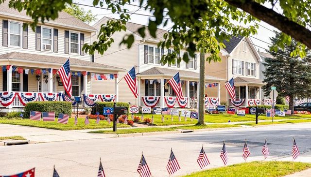 Suburban homes celebrating fourth of july displaying american flags, bunting, lawn signs